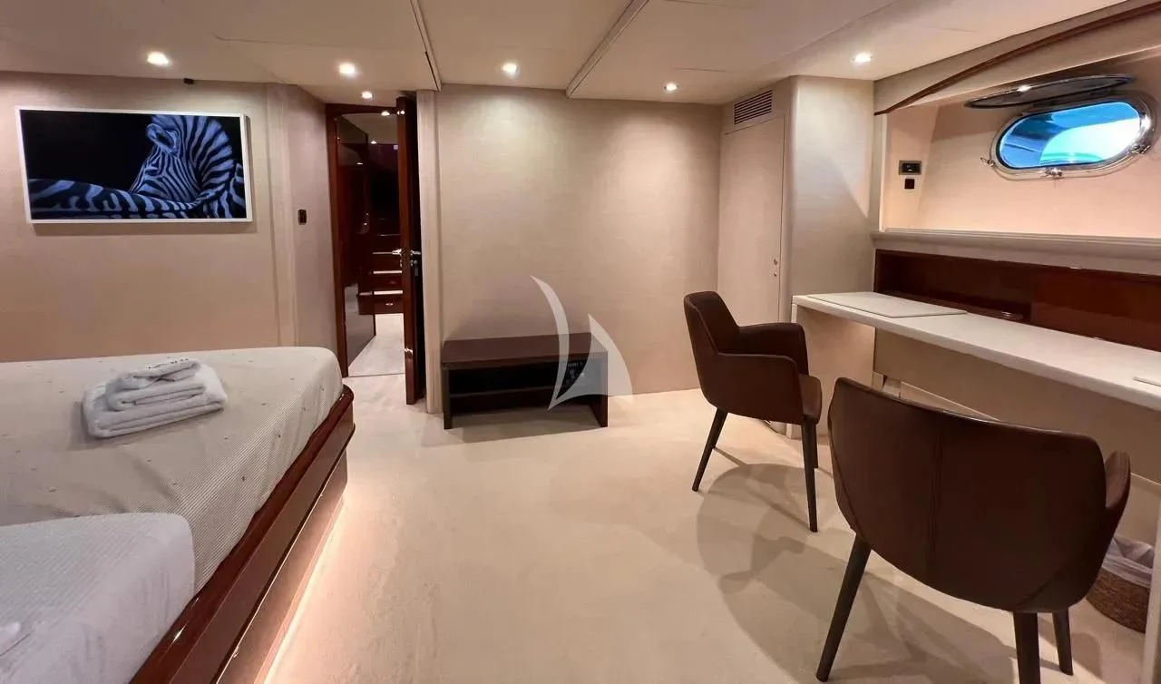 a room with a bed and chairs aboard THEION Yacht for Sale