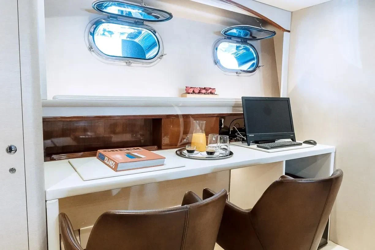 a desk with a laptop and a monitor on it aboard THEION Yacht for Sale