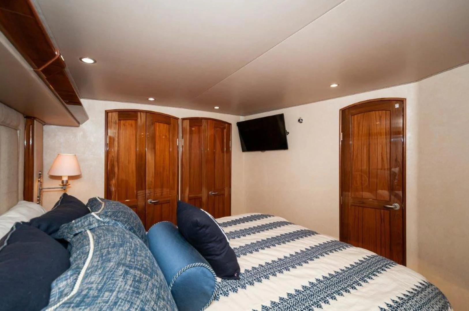 a bedroom with a bed and a wood door aboard POUR INTENTIONS Yacht for Sale