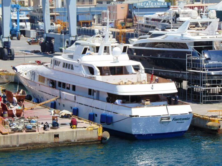 a large white boat sits in the harbor aboard FANTASIA Yacht for Sale
