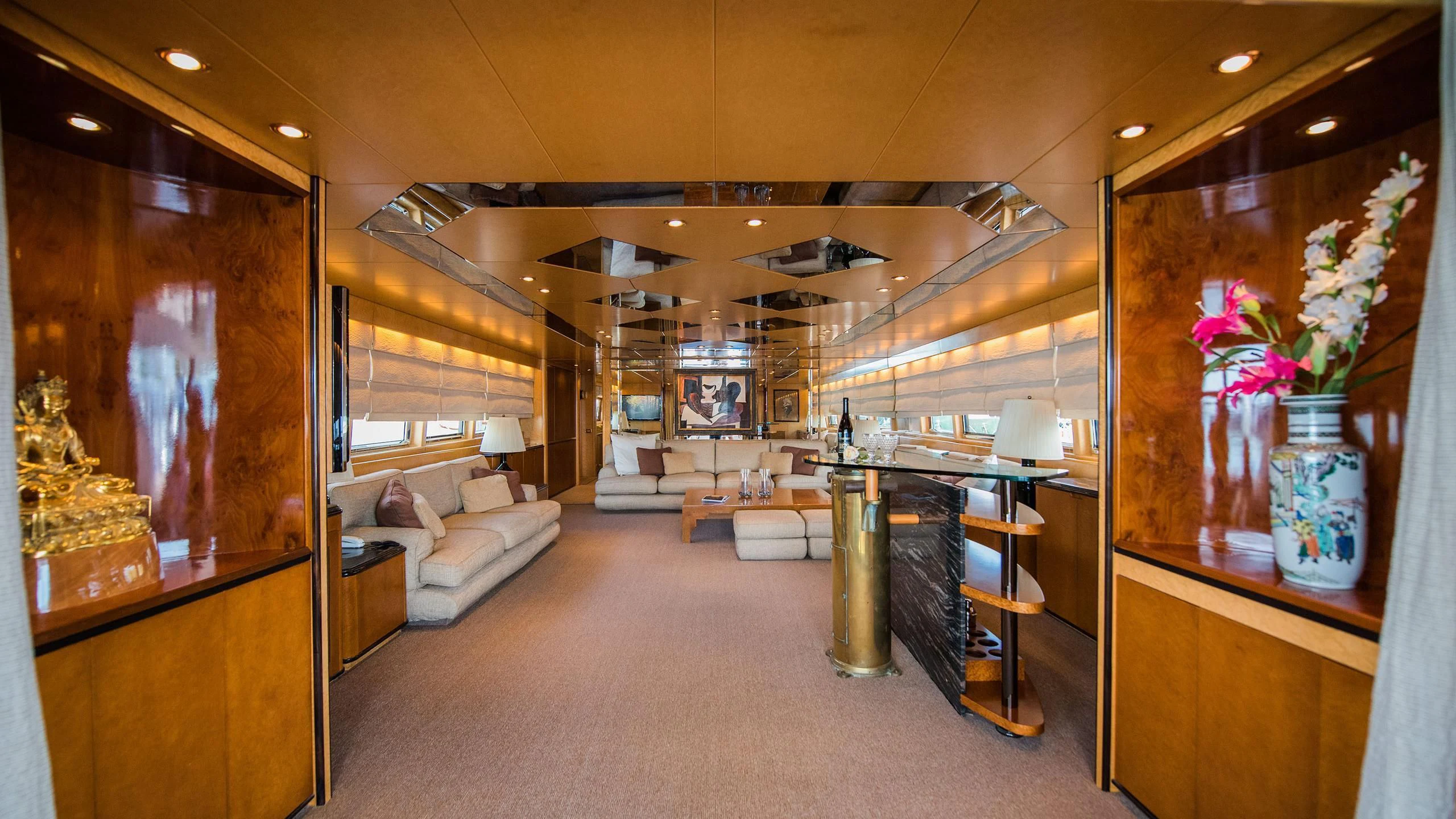 a room with a couch and a table and a vase with flowers aboard CHATO Yacht for Sale