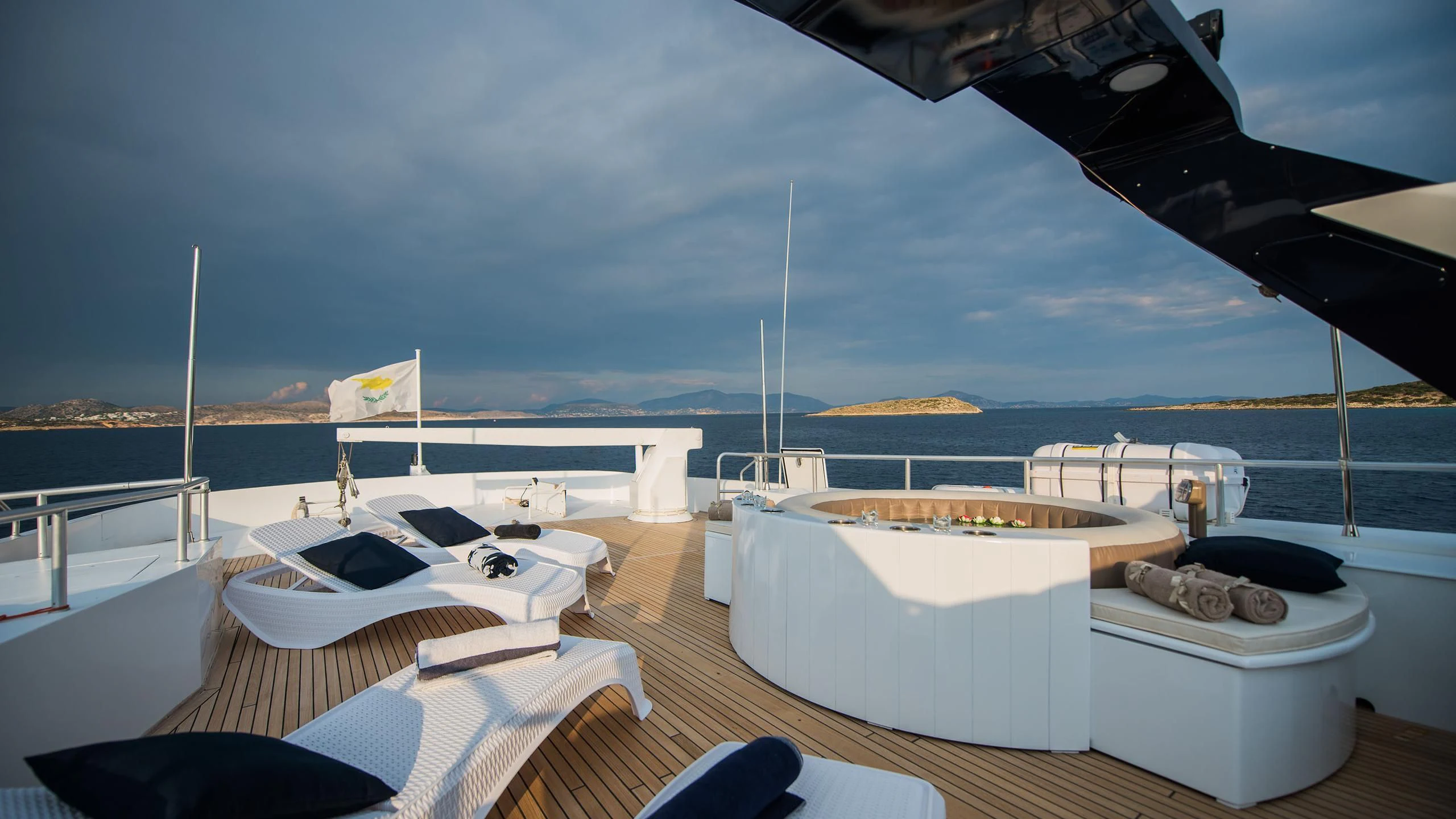 a deck with a large white table and chairs on it aboard CHATO Yacht for Sale