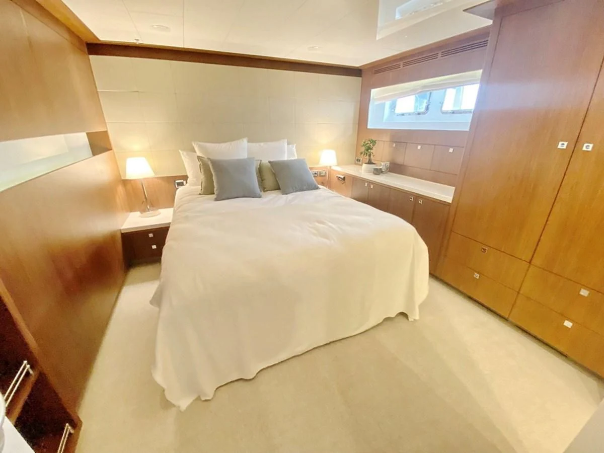 a bedroom with a bed and a desk aboard O Yacht for Sale