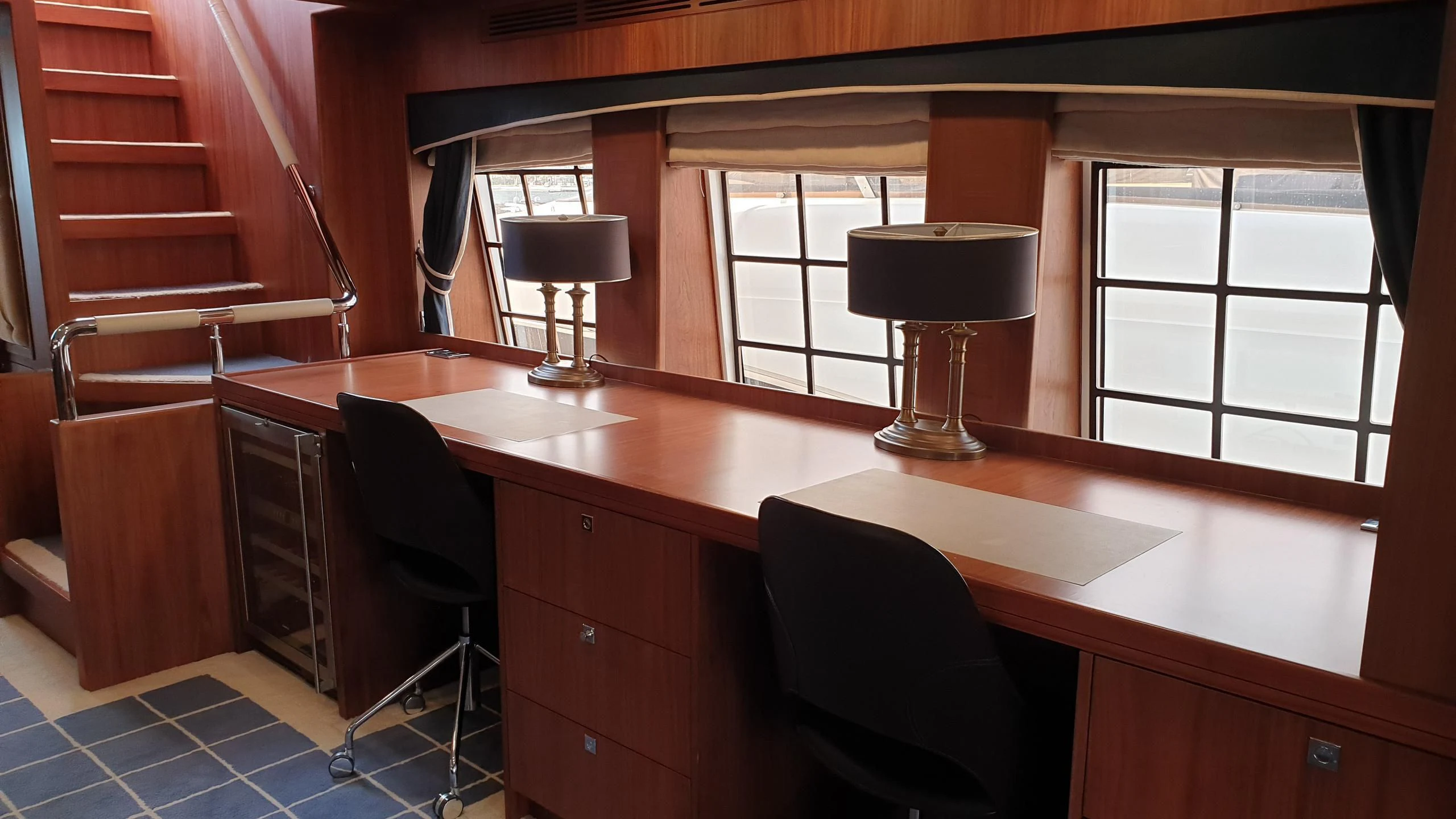 a room with a desk and a lamp aboard O Yacht for Sale