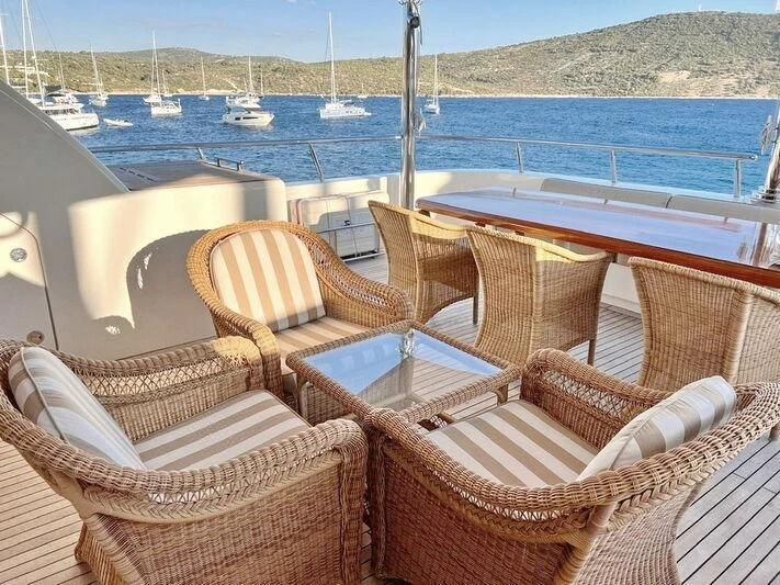 a group of chairs on a deck overlooking a body of water aboard O Yacht for Sale