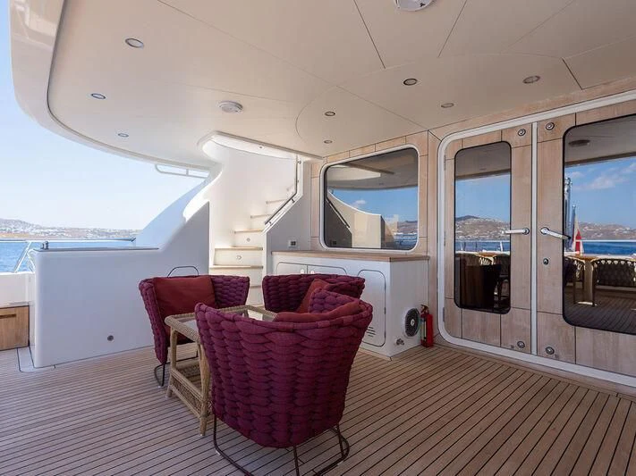 a boat with a deck and chairs aboard O Yacht for Sale