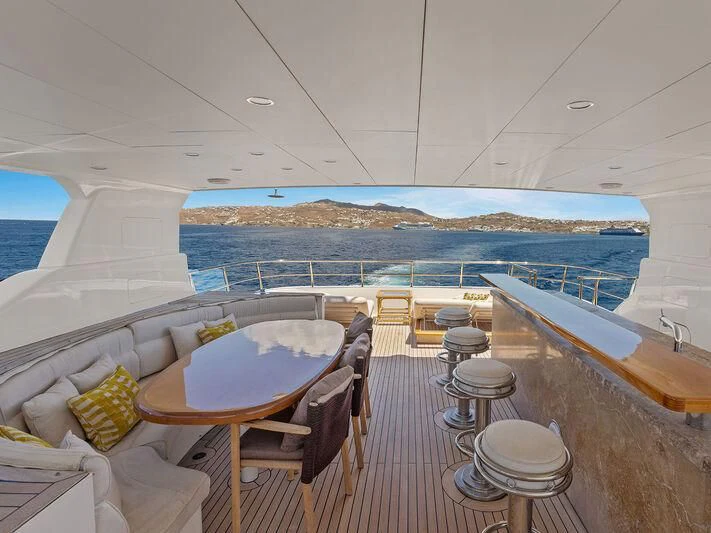 a room with a table chairs and a large body of water aboard O Yacht for Sale
