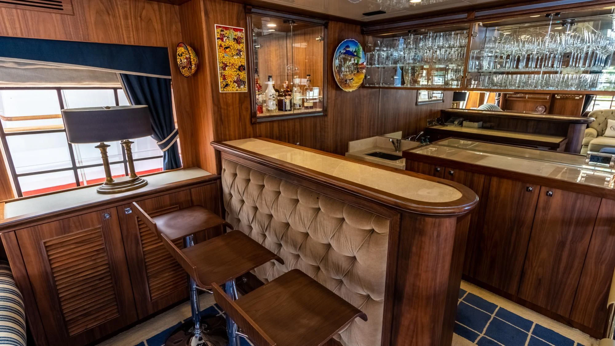 a kitchen with a bar and stools aboard O Yacht for Sale