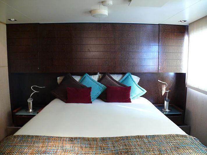 a bed with pillows and a lamp aboard ALTER EGO Yacht for Sale