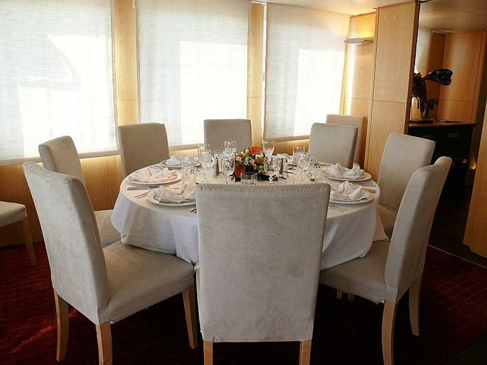 a dining room table set for a dinner party aboard ALTER EGO Yacht for Sale