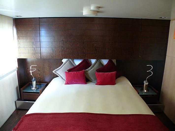 a bed with red pillows aboard ALTER EGO Yacht for Sale