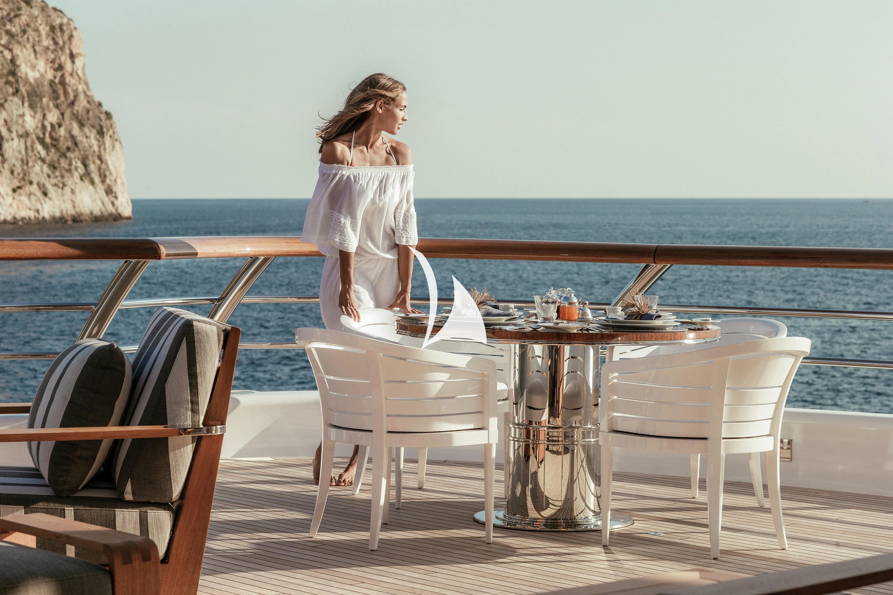 a person sitting on a table aboard AQUILA Yacht for Sale