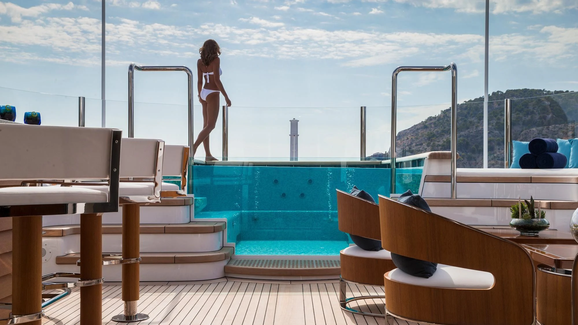 a person standing on a balcony overlooking a body of water aboard AQUILA Yacht for Sale