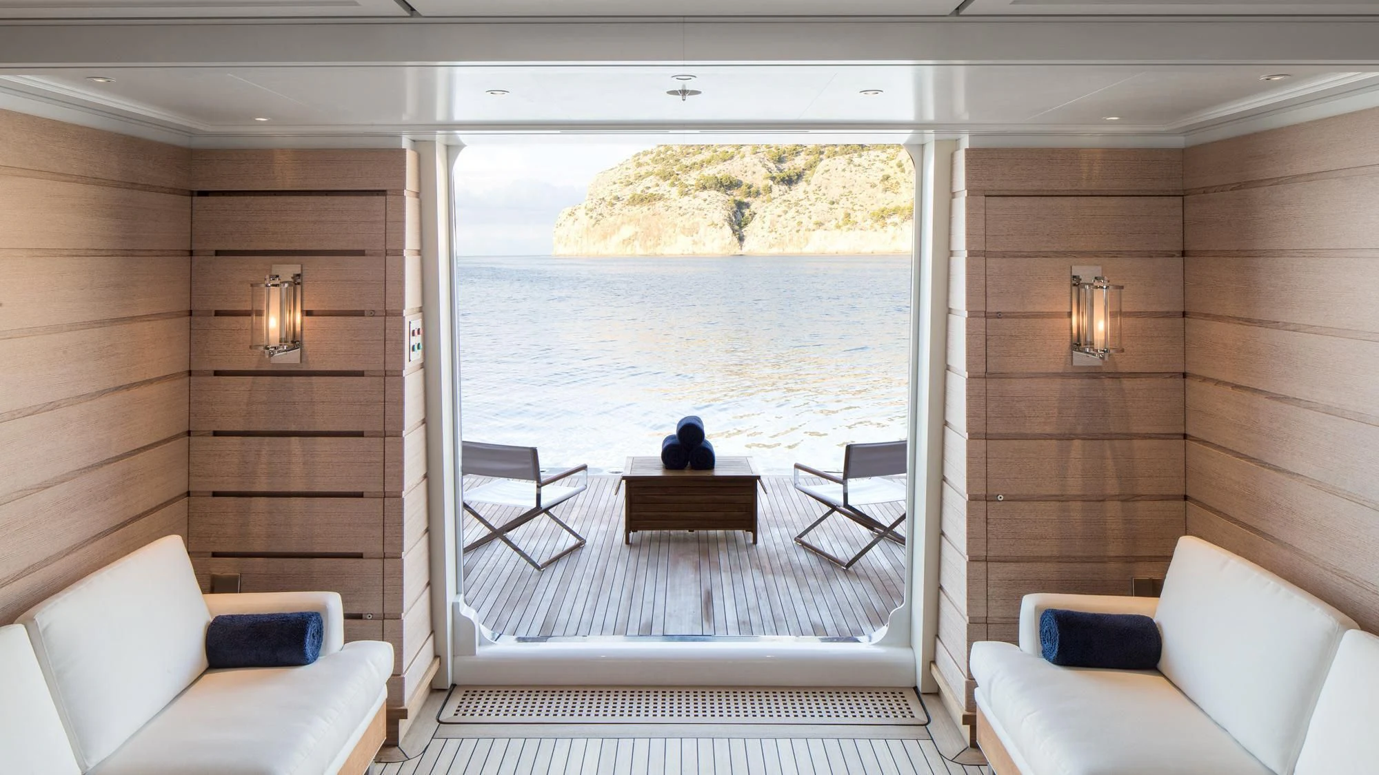 a room with a view of the water and a beach aboard AQUILA Yacht for Sale