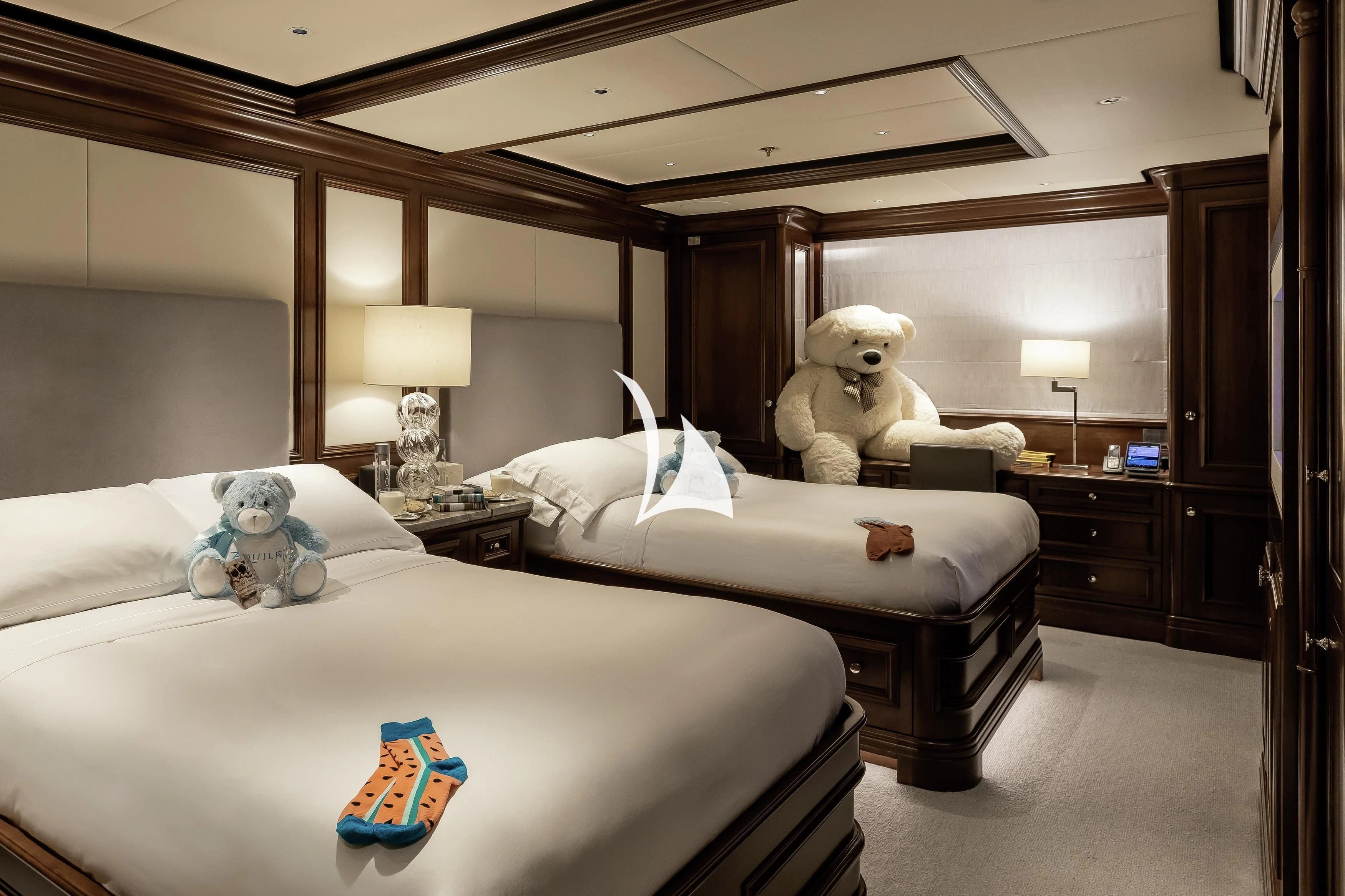 a hotel room with a couple of teddy bears on the bed aboard AQUILA Yacht for Sale
