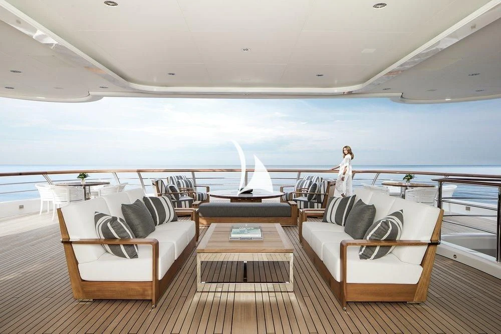 a room with a couch and a table and a large body of water aboard AQUILA Yacht for Sale