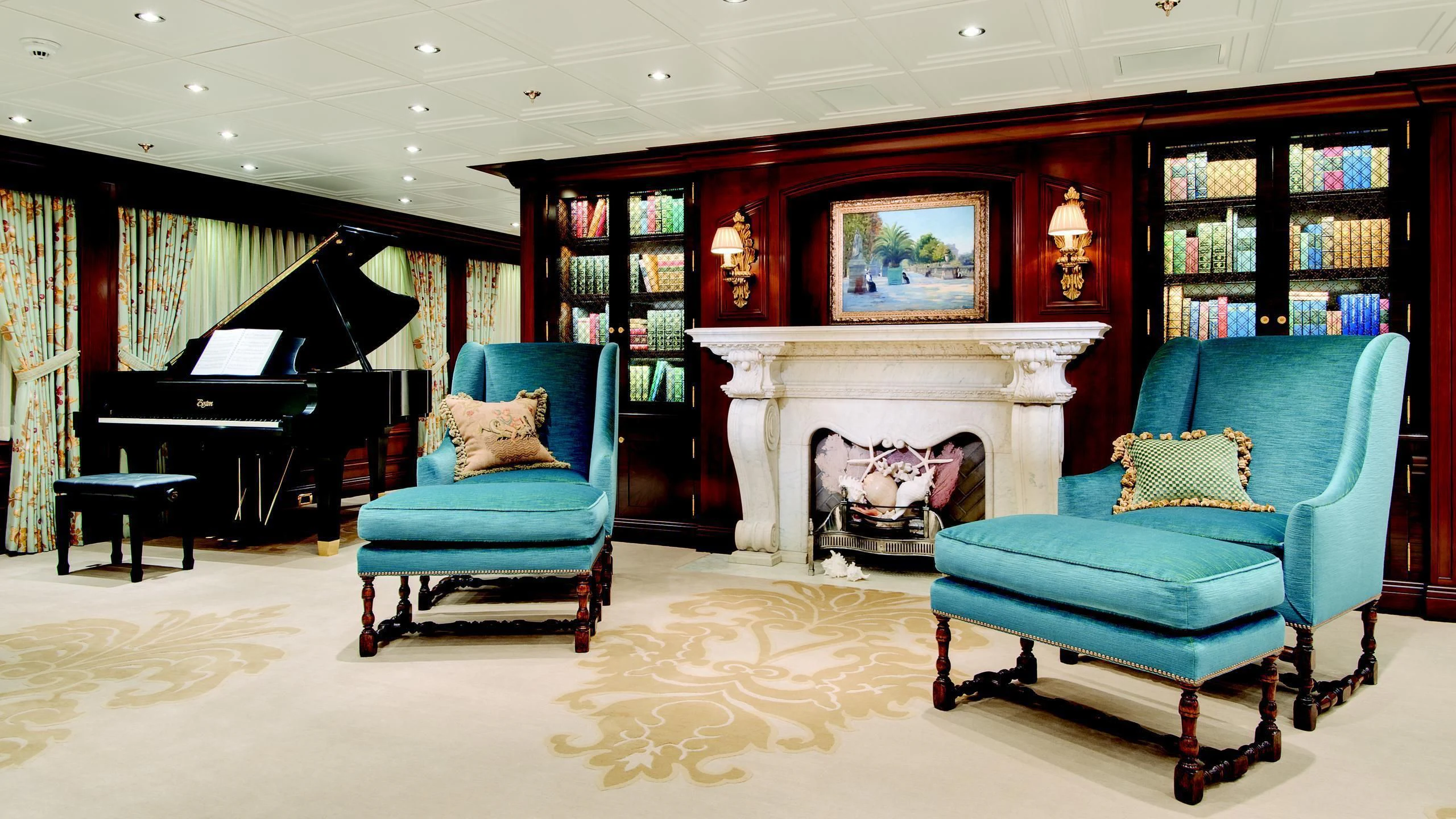 a living room with blue chairs and a fireplace aboard AQUILA Yacht for Sale