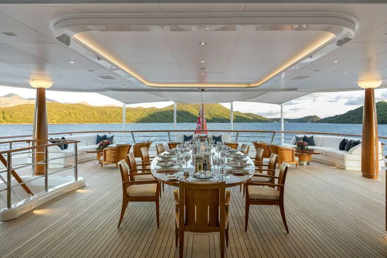 a table set for a meal on a deck aboard AQUILA Yacht for Sale