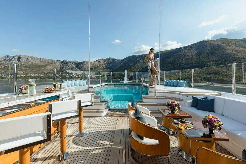 a person standing on a deck overlooking a body of water aboard AQUILA Yacht for Sale