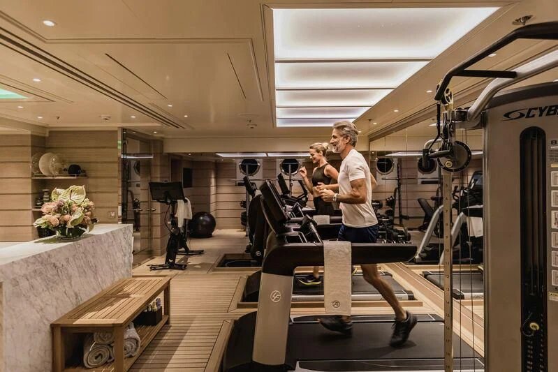 a man and woman in a gym aboard AQUILA Yacht for Sale
