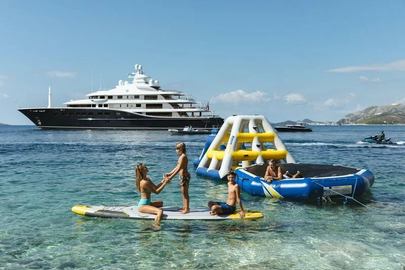 a group of people on surfboards in the water aboard AQUILA Yacht for Sale