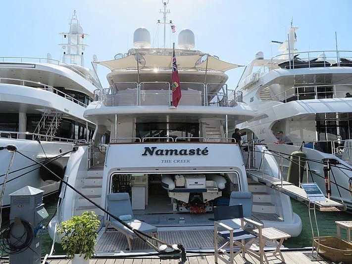 a large white boat with flags aboard NAMASTE Yacht for Sale