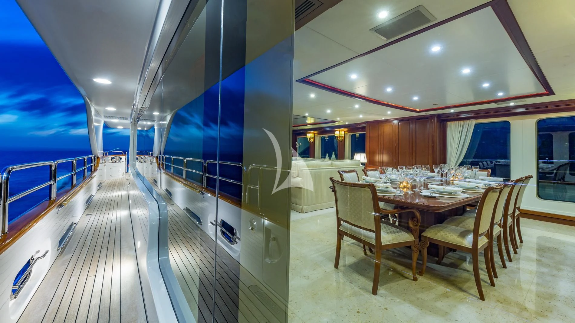 a long table and chairs in a room with a large window aboard NAMASTE Yacht for Sale