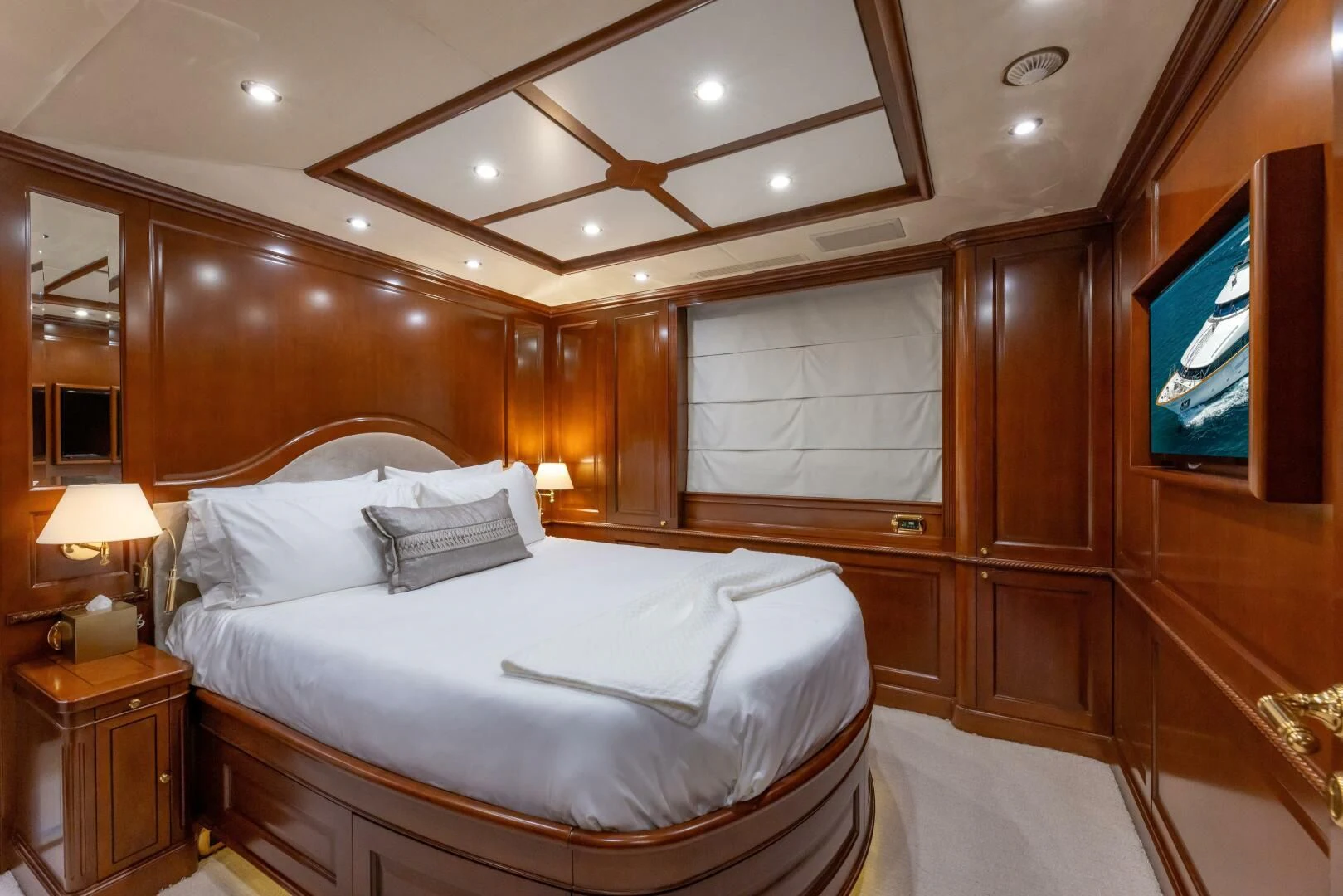 a bedroom with a bed and a wood cabinet aboard NAMASTE Yacht for Sale