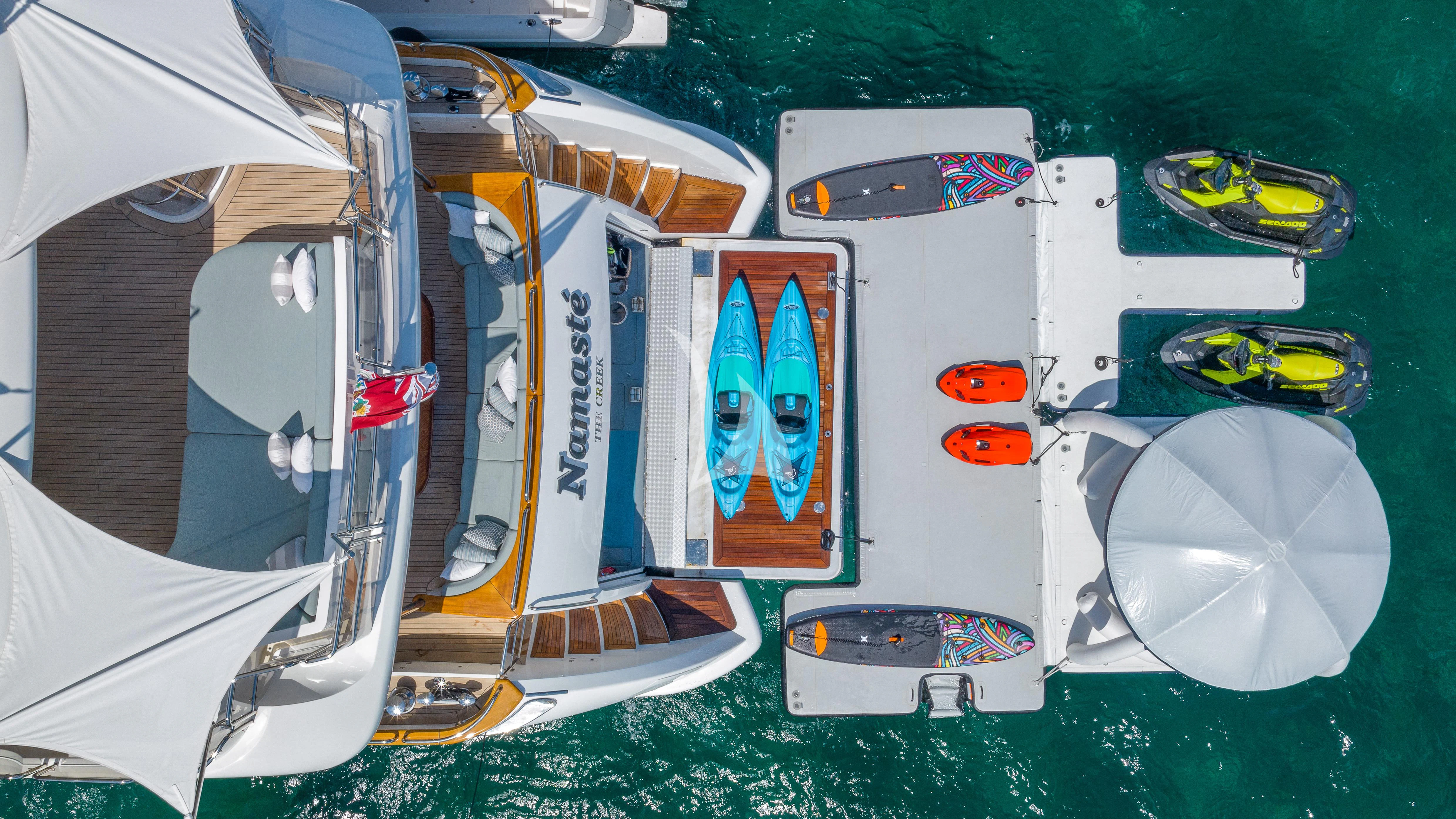a group of white and black boats on a green water body aboard NAMASTE Yacht for Sale