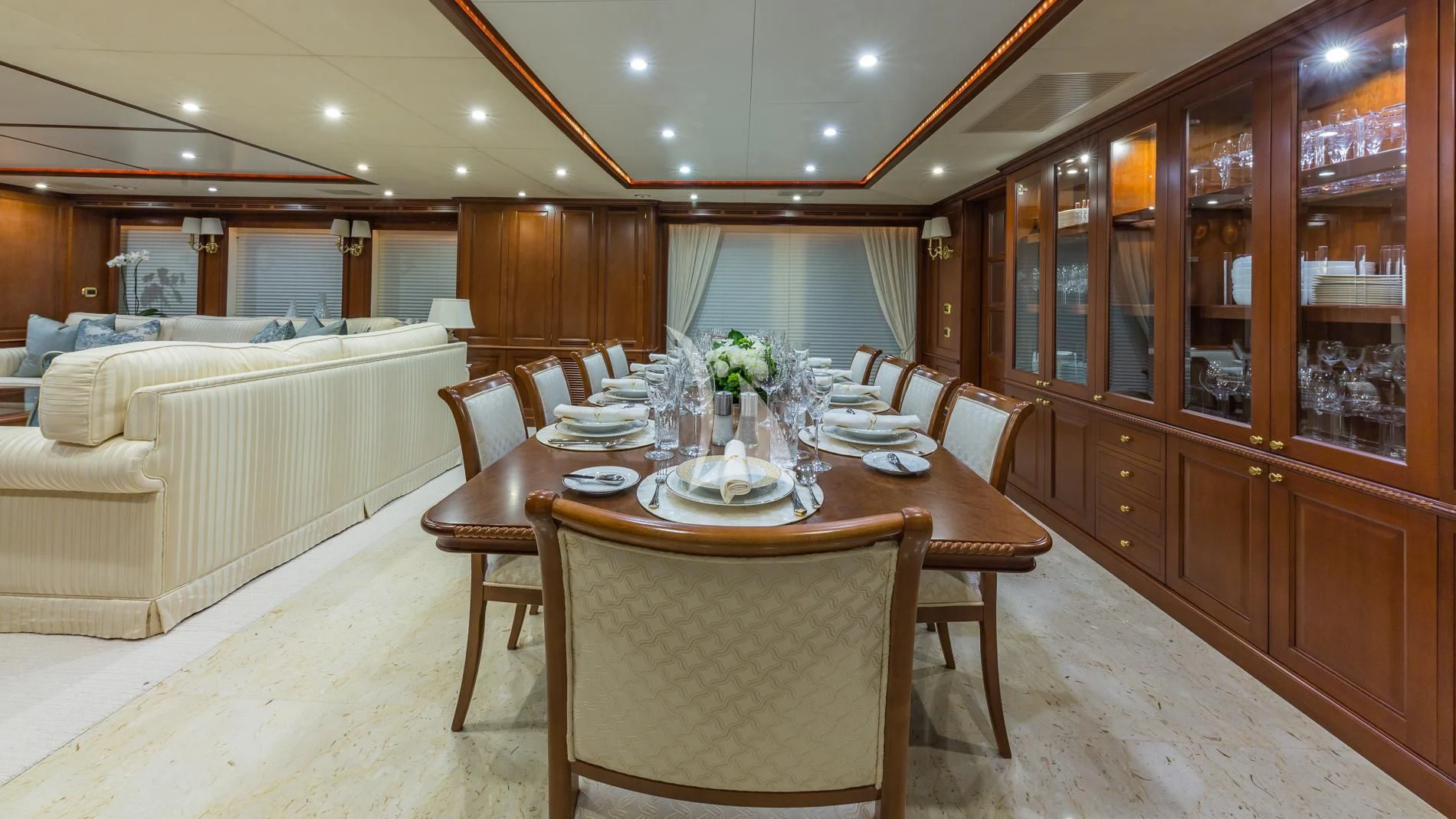 a dining table and chairs in a room with a bed and cabinets aboard NAMASTE Yacht for Sale