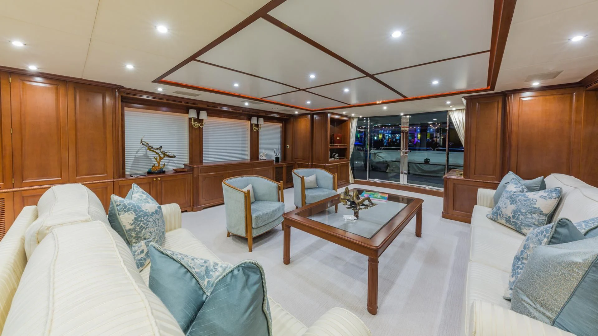 a living room with a large wood cabinet and a round table aboard NAMASTE Yacht for Sale