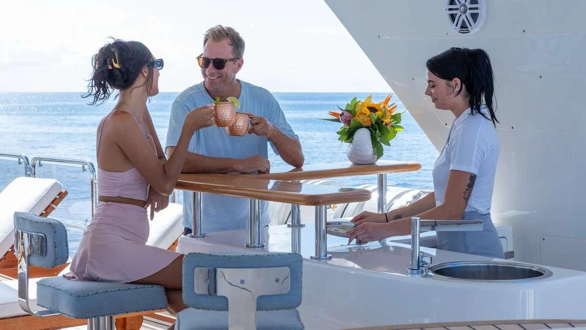 a man and a woman sitting at a table with food and drinks aboard NAMASTE Yacht for Sale