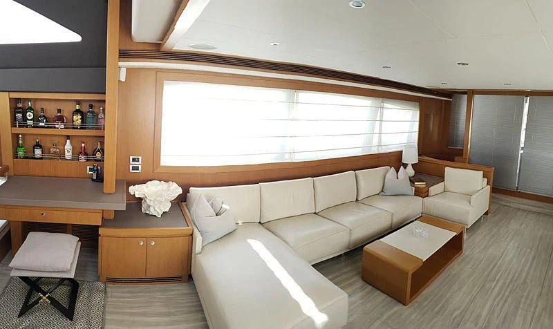 a room with a couch and a coffee table aboard ALL RUMORS Yacht for Sale