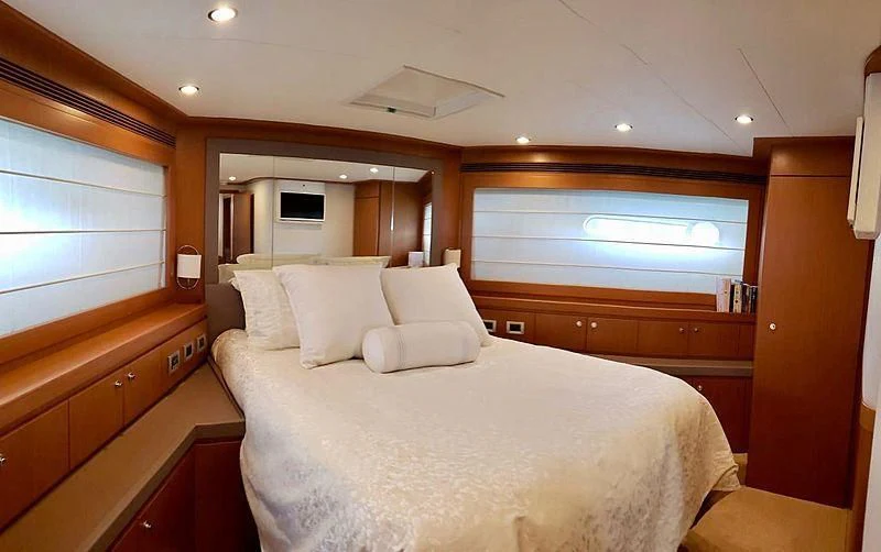 a bedroom with a bed and a television aboard ALL RUMORS Yacht for Sale