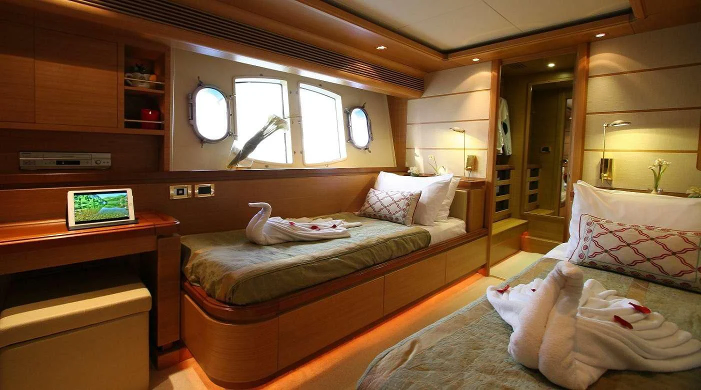 a room with beds and a desk aboard PAREAKKI Yacht for Sale