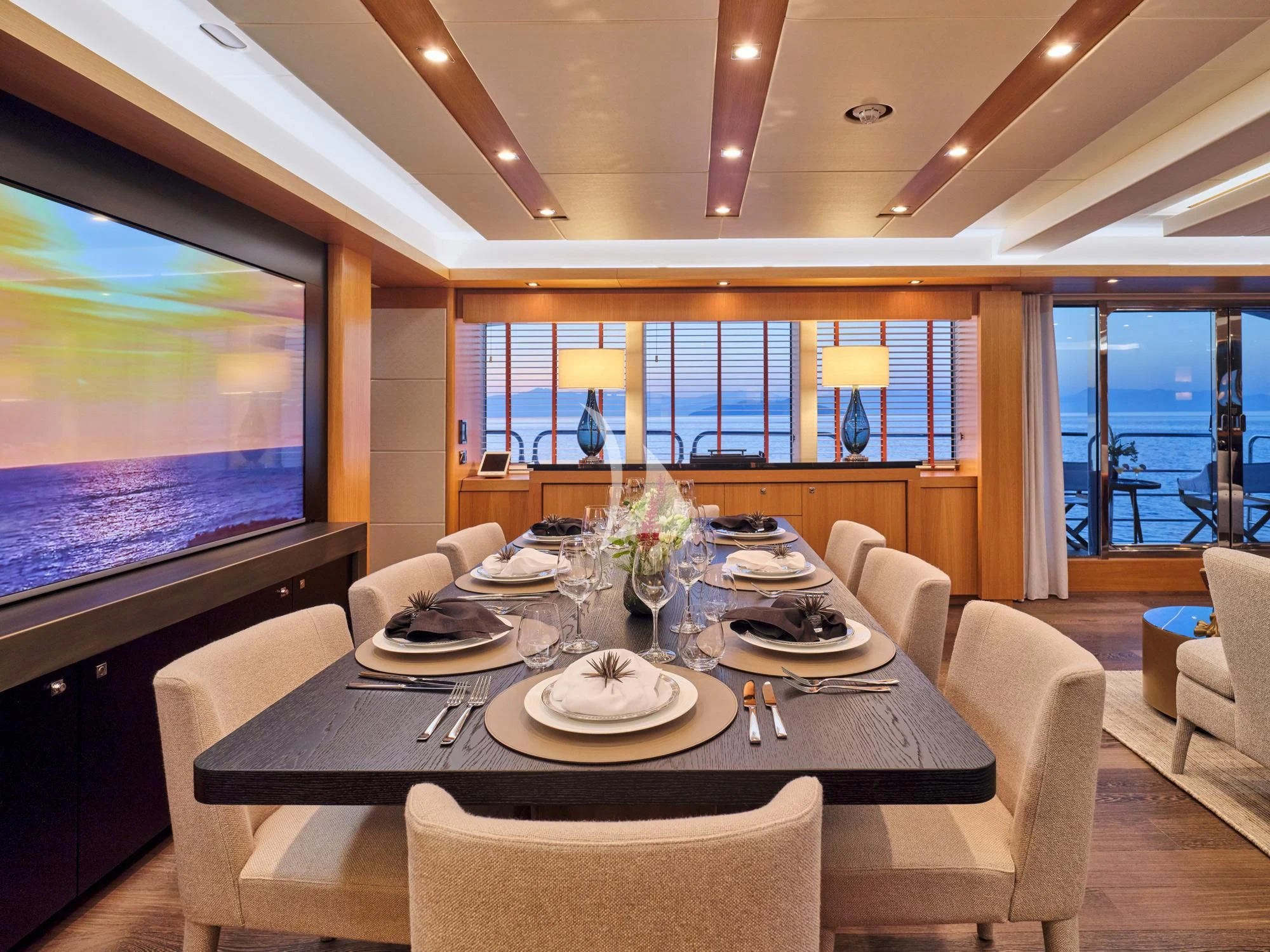a dining room with a large screen aboard MAKANI II Yacht for Charter