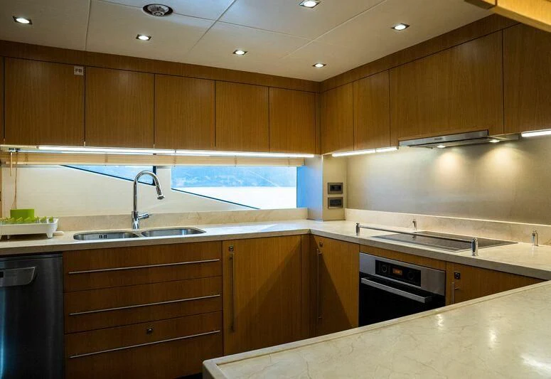 a kitchen with wooden cabinets aboard MAKANI II Yacht for Charter