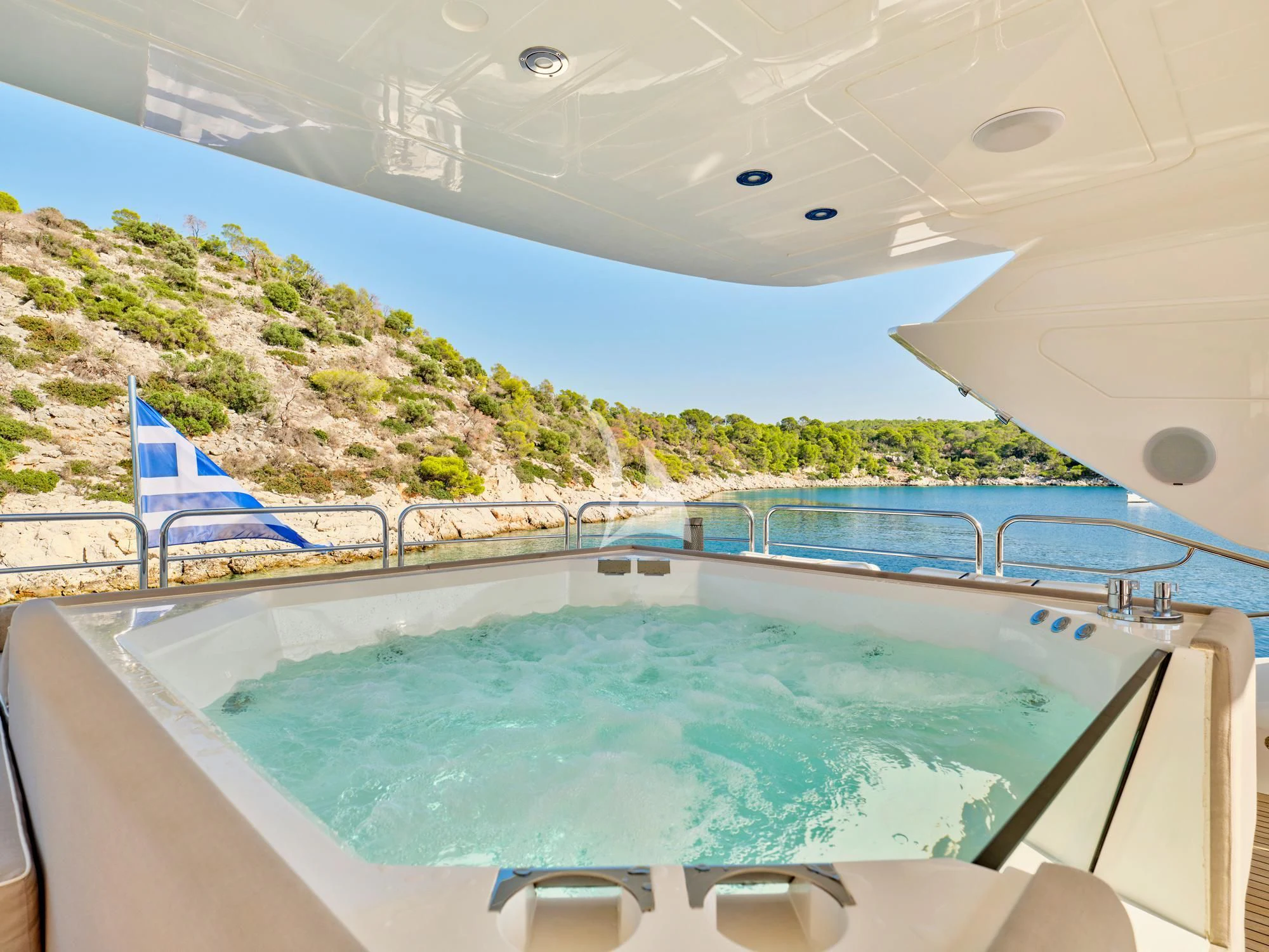 a swimming pool with a blue lounge chair and a blue chair on a sunny day aboard MAKANI II Yacht for Charter