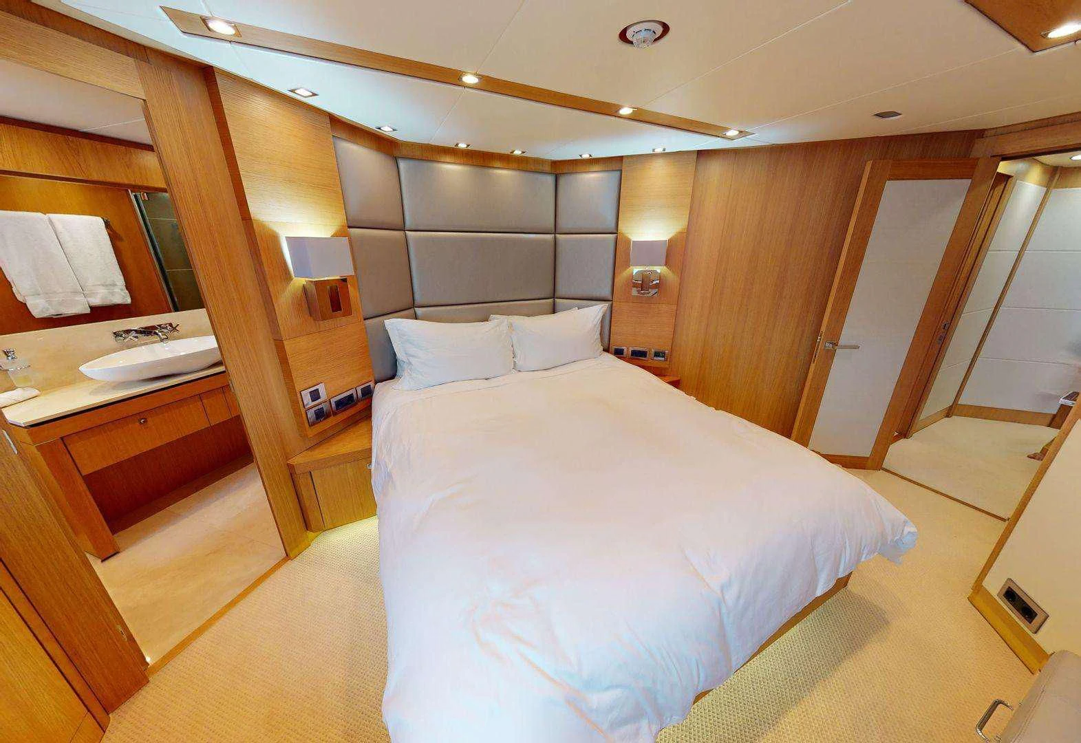 a bedroom with a bed and desk aboard MAKANI II Yacht for Charter