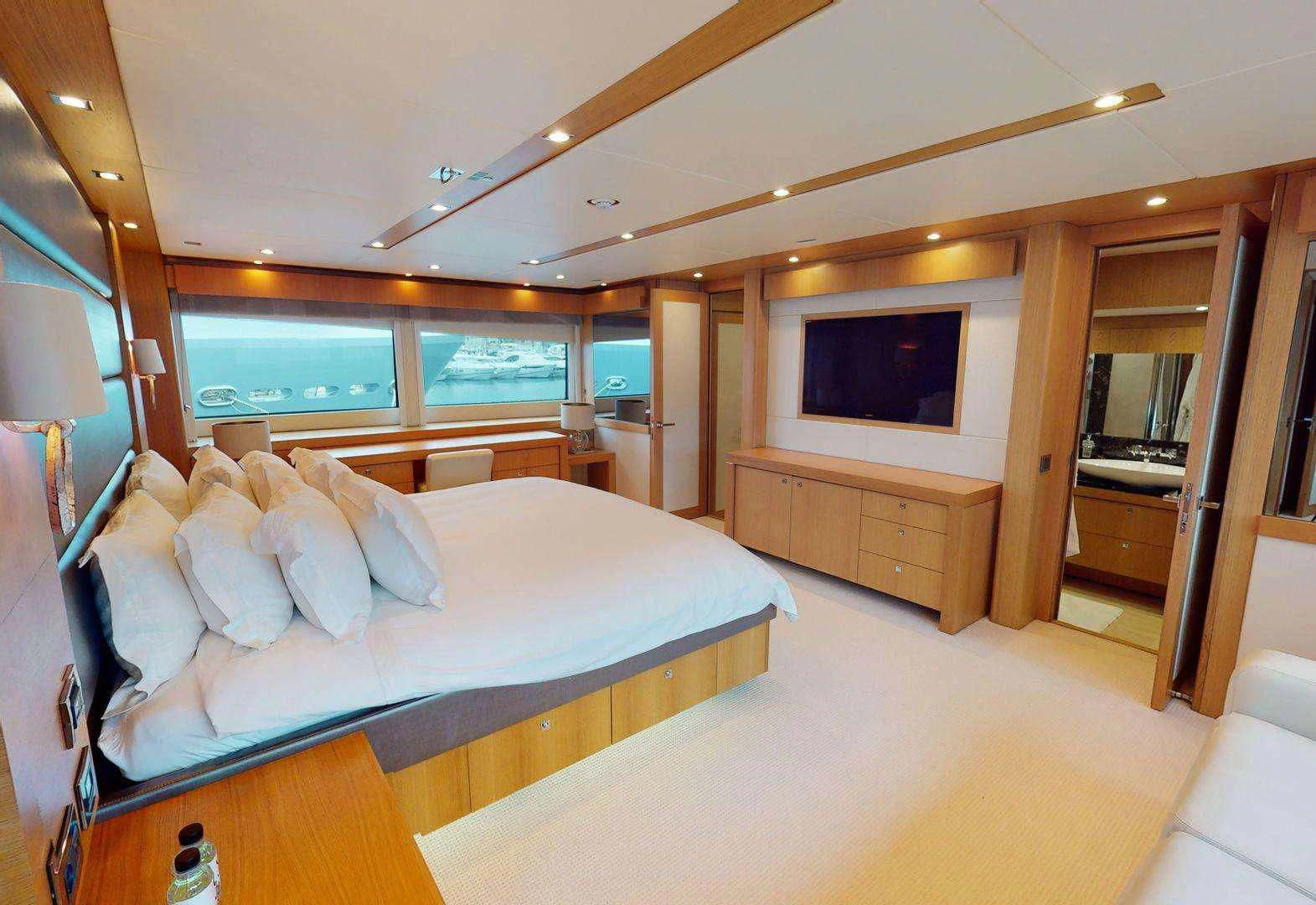 a bedroom with a bed and a tv aboard MAKANI II Yacht for Charter