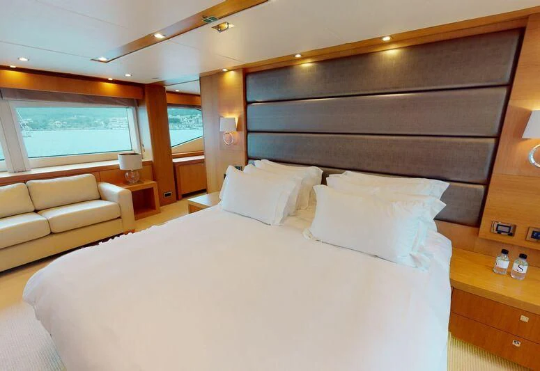 a bed with white sheets and pillows aboard MAKANI II Yacht for Charter