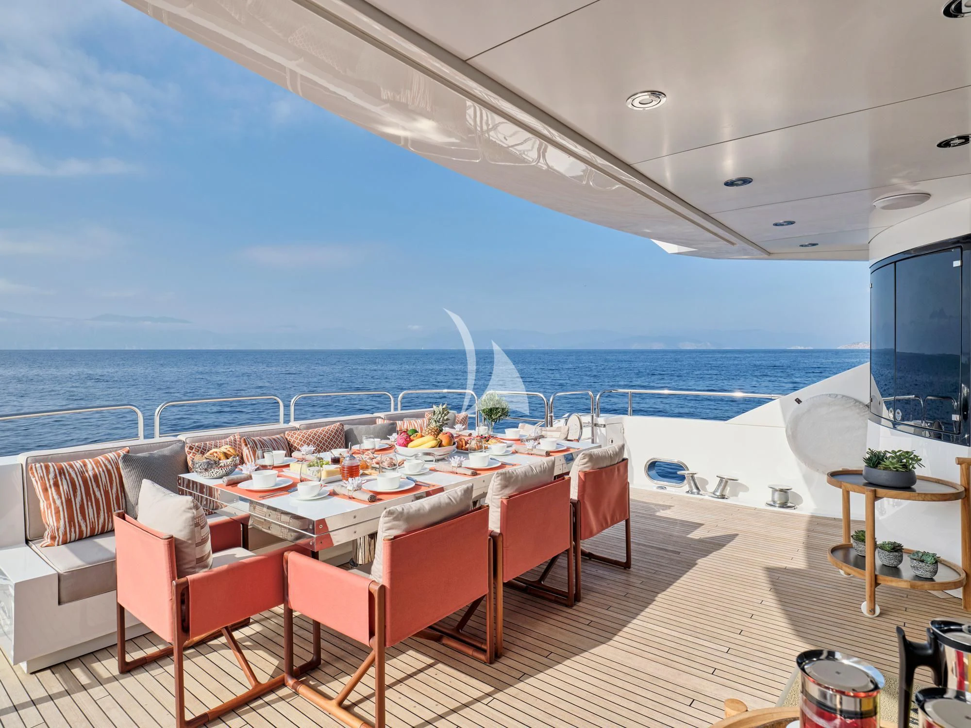 a table set for a meal on a deck overlooking the ocean aboard MAKANI II Yacht for Charter