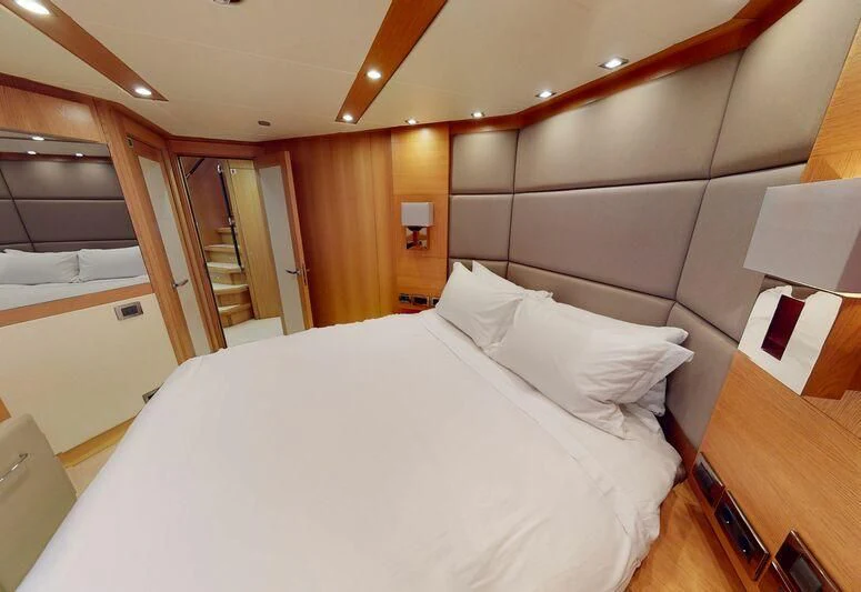 a bed with white sheets aboard MAKANI II Yacht for Charter