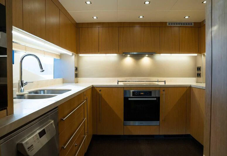 a kitchen with wooden cabinets aboard MAKANI II Yacht for Charter