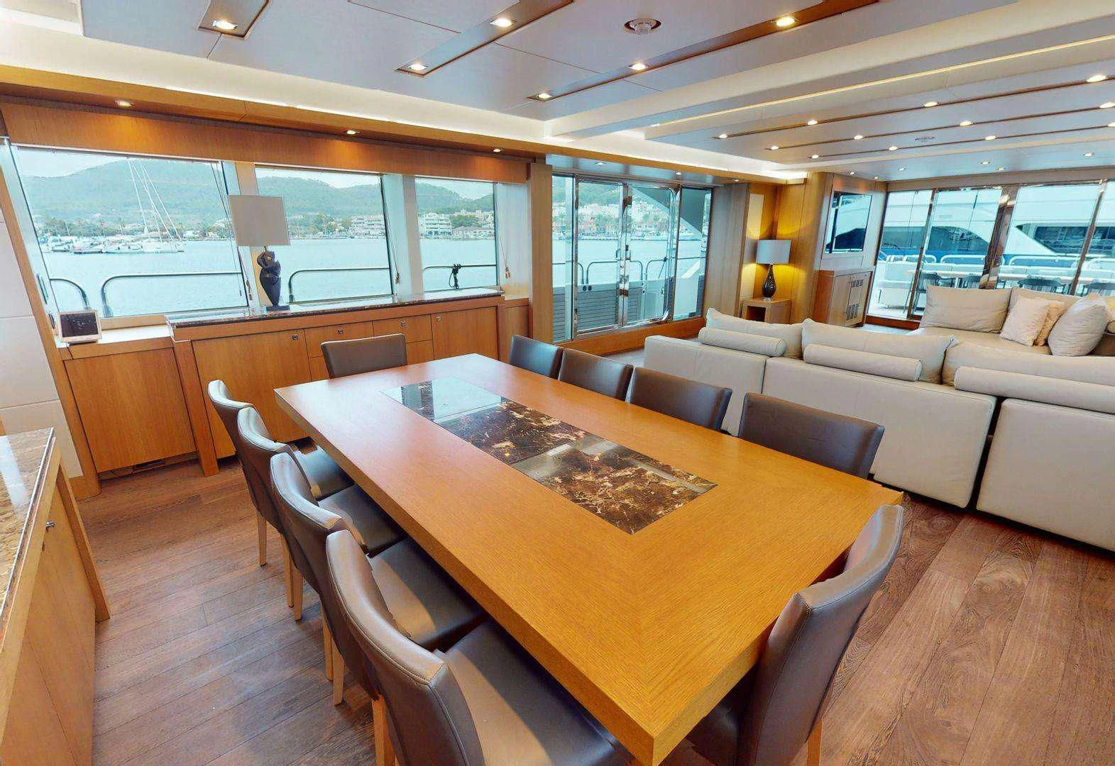 a large living room with a large table and chairs aboard MAKANI II Yacht for Charter