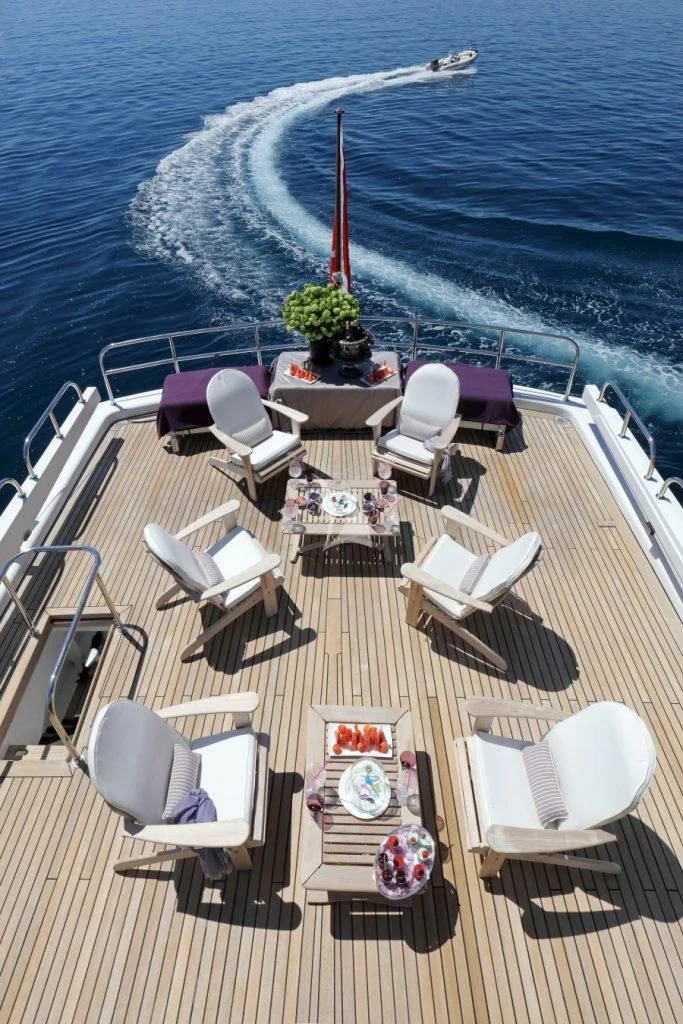 chairs and tables on a deck overlooking a body of water aboard SEA LADY II Yacht for Sale