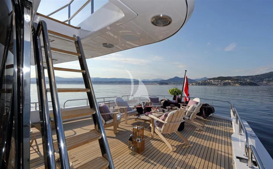 a deck with chairs and tables on it and water in the background aboard SEA LADY II Yacht for Sale