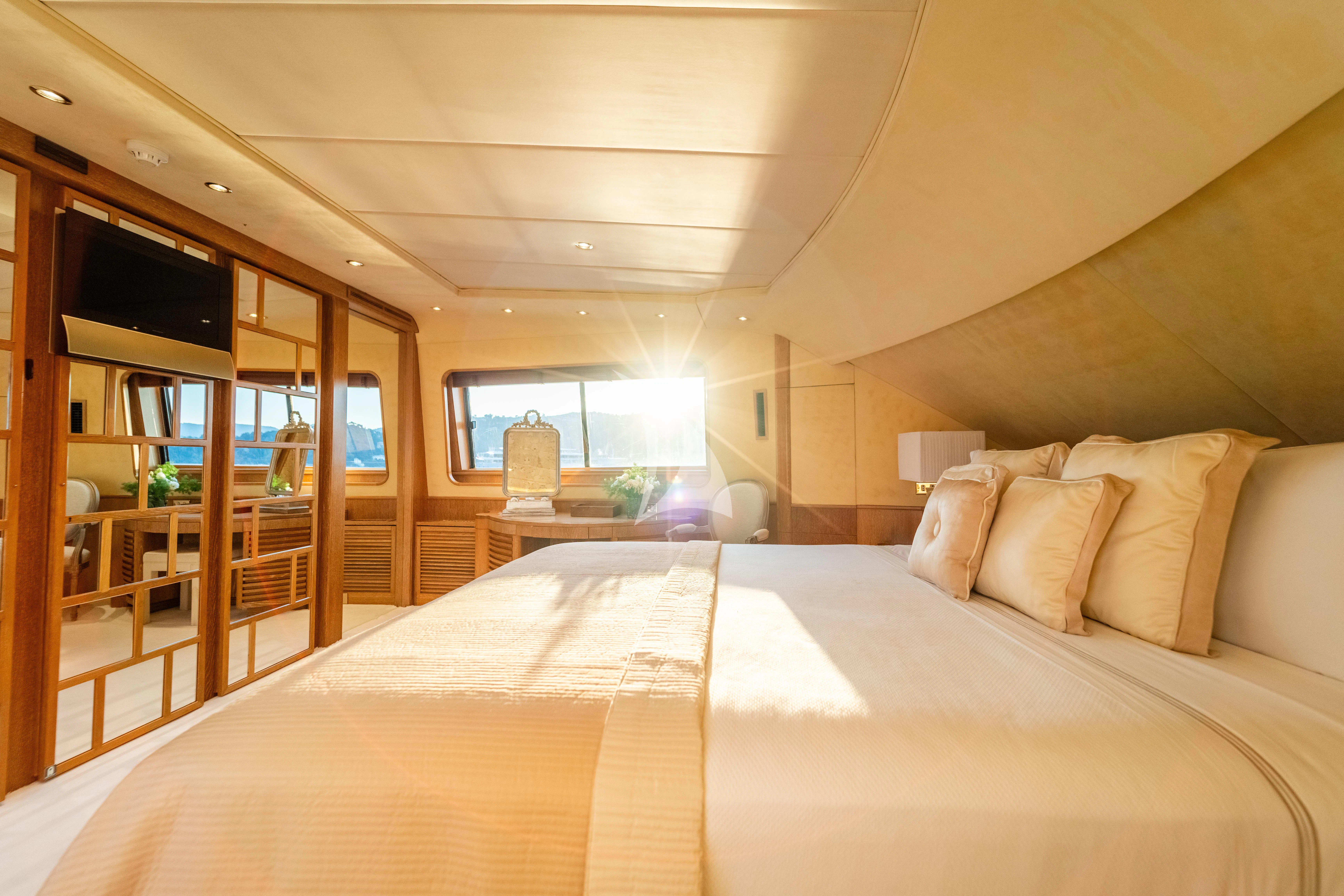 a bed with a white comforter aboard SEA LADY II Yacht for Sale