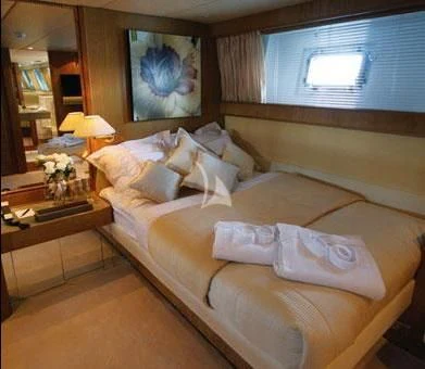 a bed with a white bed spread aboard SEA LADY II Yacht for Sale