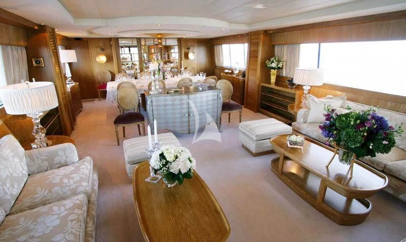 a large living room with a dining table and chairs aboard SEA LADY II Yacht for Sale
